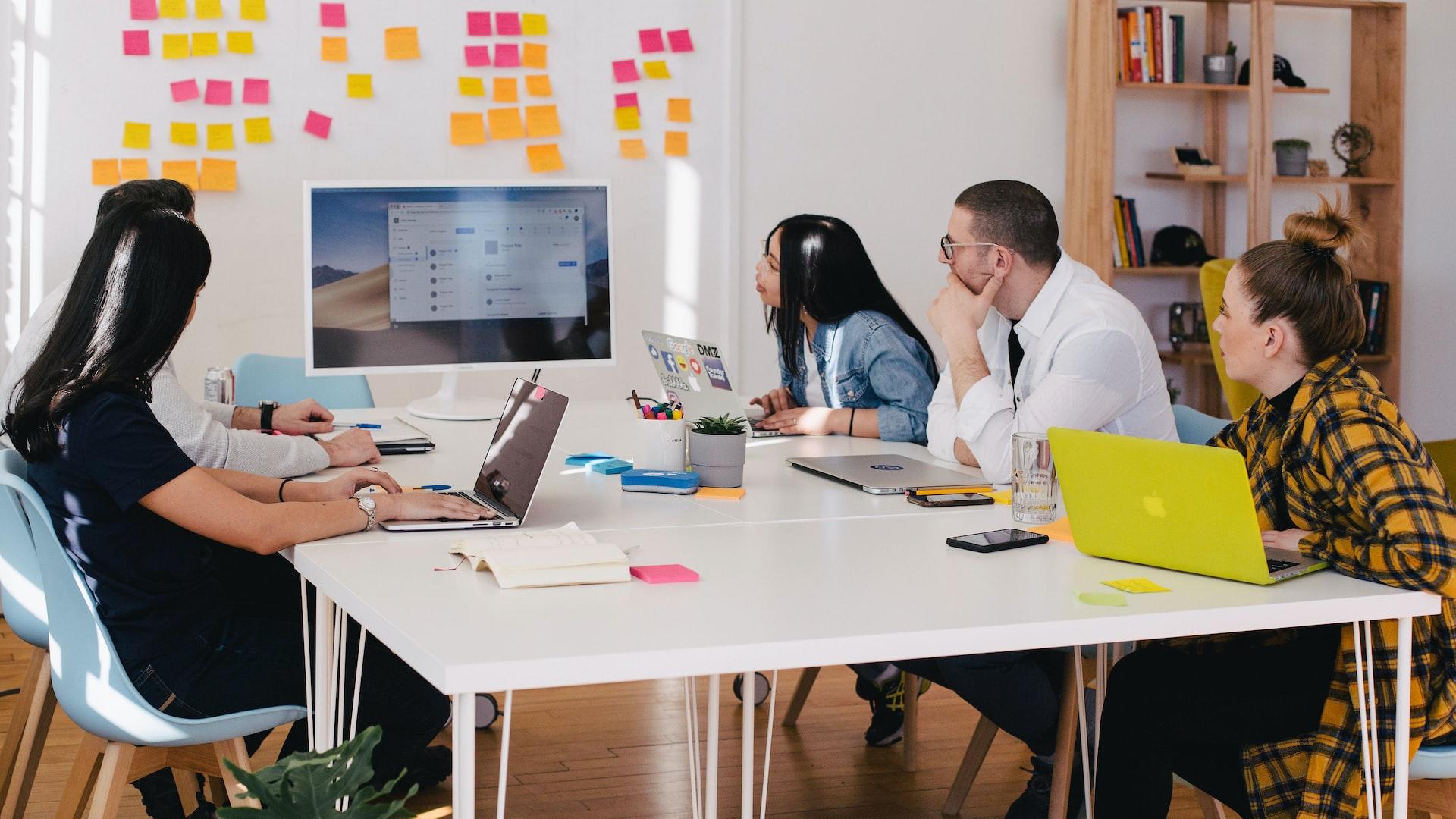 five person by table watching turned on white iMac